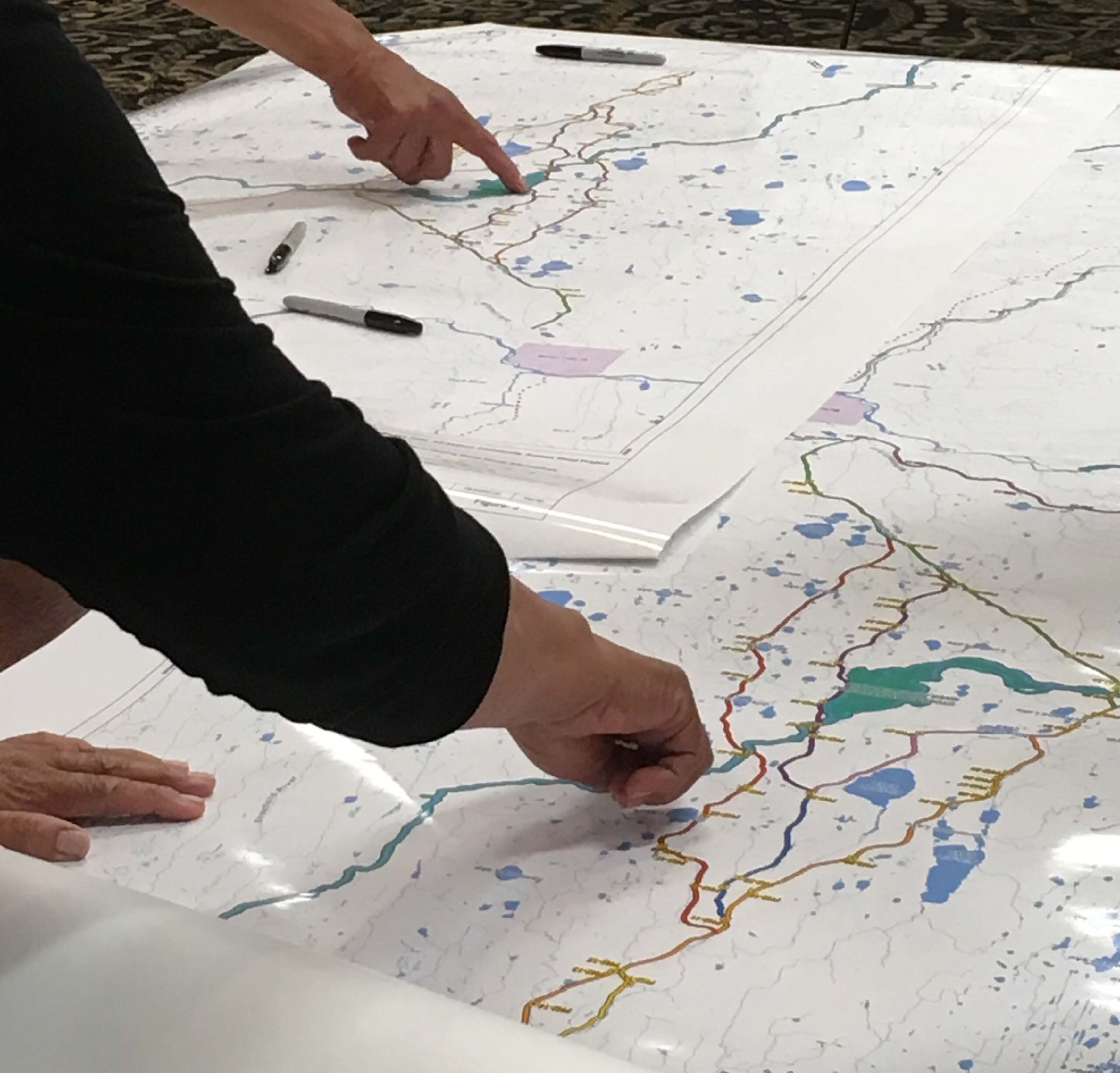 A photo of a person pointing at a map of the Marten Falls area.