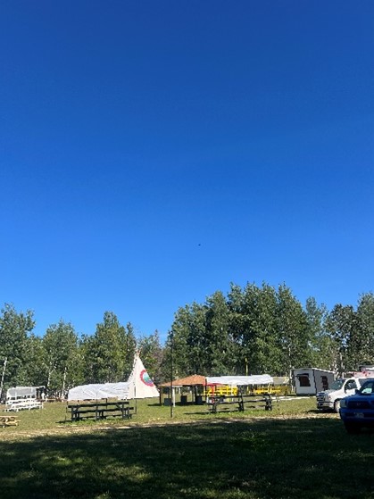 Photo of the Marten Falls First Nation Powwow with a teepee and covered booths. Photo of the Marten Falls First Nation Powwow with a teepee and covered booths.