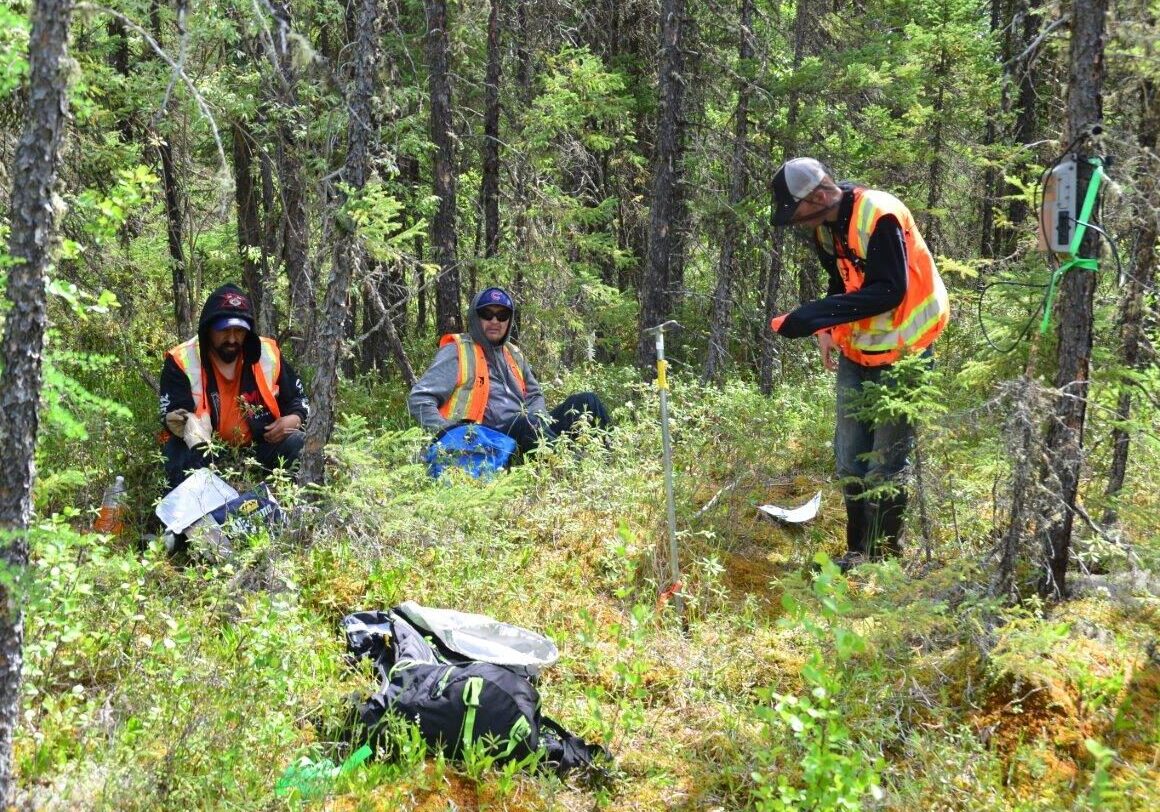 DSC_7978 A photo of workers conducting soil sampling and field studies analysis.